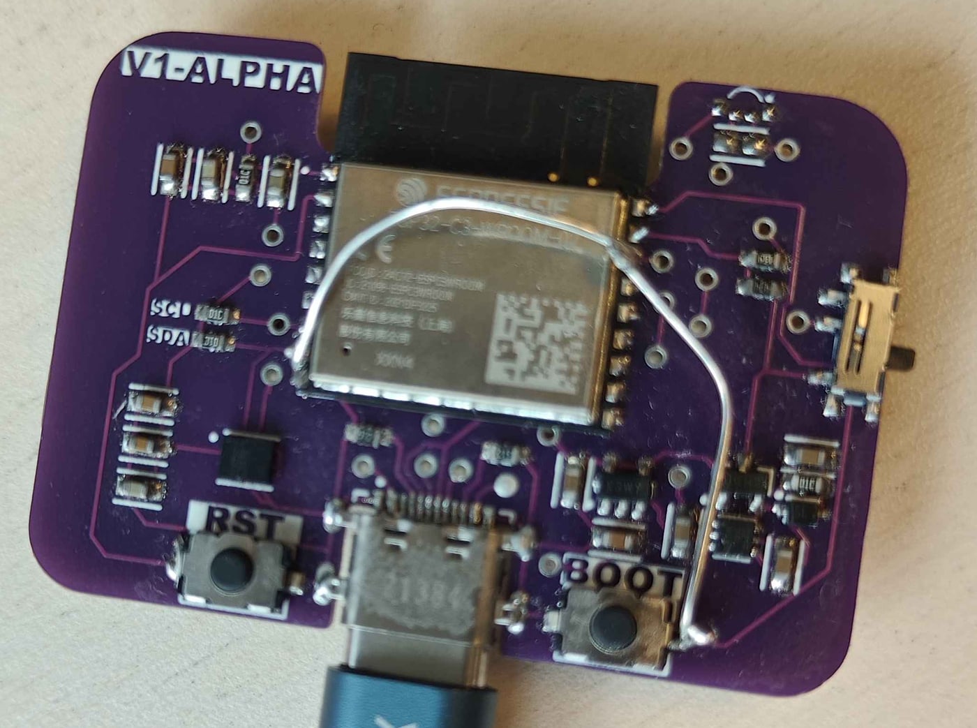 The V1-ALPHA board: ESP32-C3 module, USB-C, RST and BOOT buttons on a purple PCB