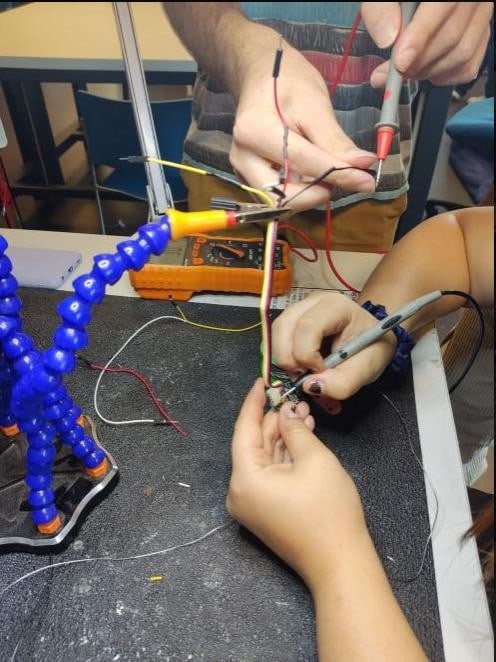 Hands soldering wires at the workbench
